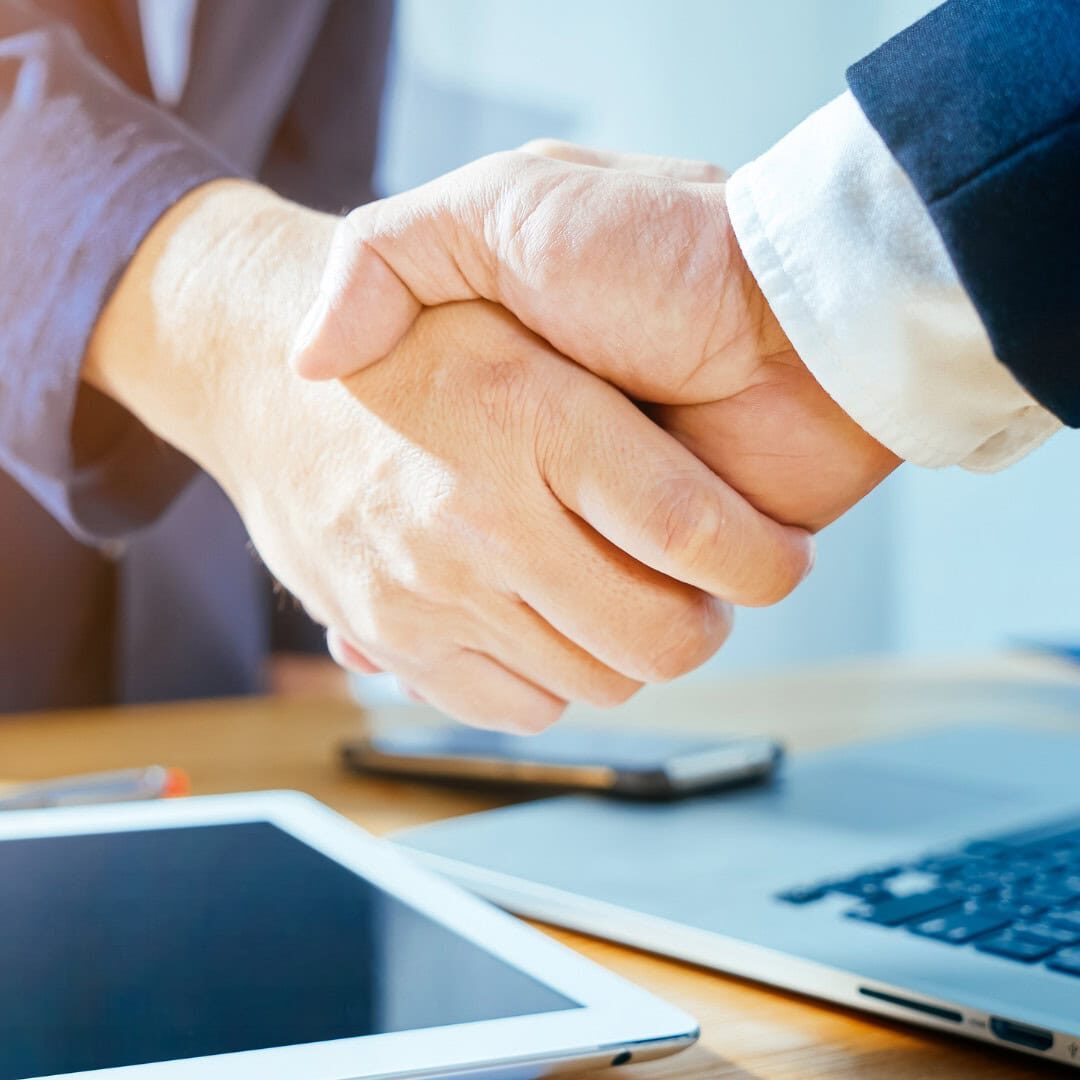 reliable service Business handshake near laptop and tablet