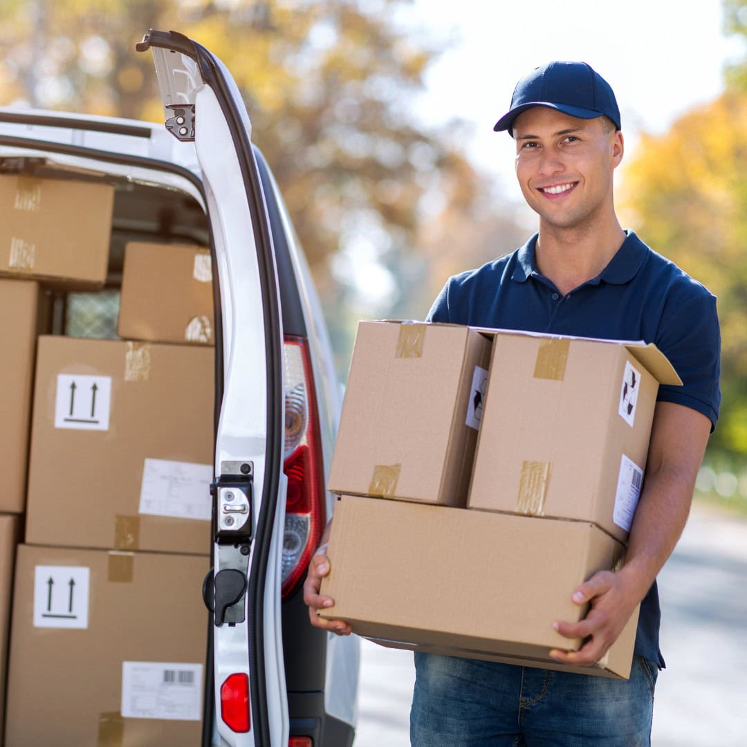 personalized delivery Smiling delivery man holding cardboard boxes near van.